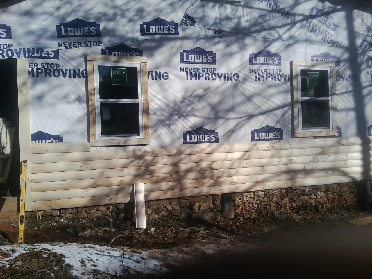 House wrap and new log siding going up on an exterior wall in Barrington