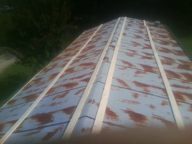 Rusted metal roof panels with new wood purlins before replacement — Storm Damage Roof Repair in Barrington by Roofing Brothers