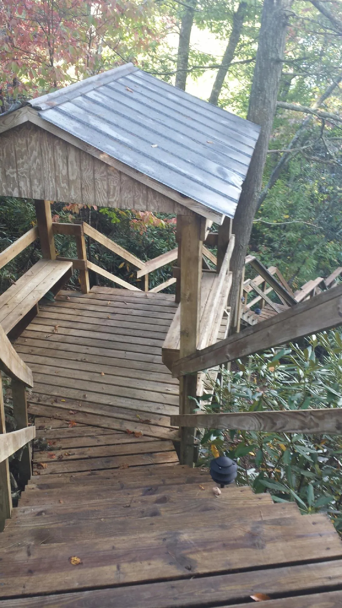 Metal roofed shelter over wooden steps on a wooded walkway — Skylight Repair & Installation work by our crew in Barrington